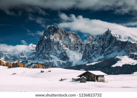 Wooden cottage in a fairy-tale winter landscape with mountains.