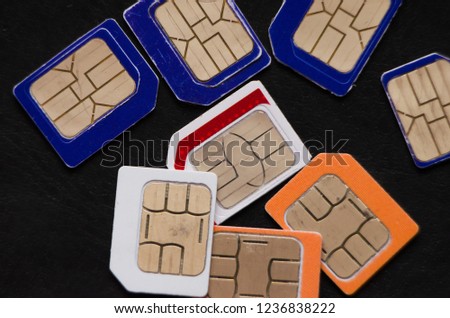 Many cellphone sim cards in different formats for black Background
