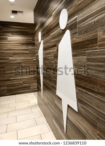 Modern restroom entrance men and women symbols on a wood background