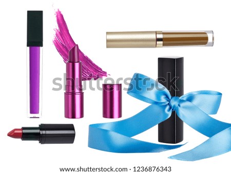 Arrangement of lipstick makeup cosmetics as a holiday gift set.  These products have a ribbon or bow to show they are on a seasonal Christmas sale.  Isolated on a white background. 