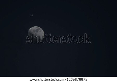 Pictures from long distance planes move on the back of the moon in the evening