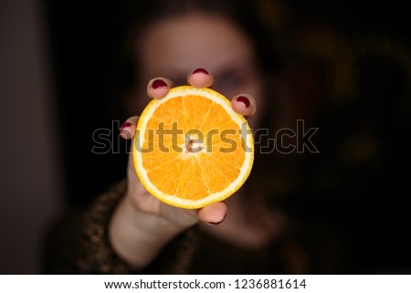 Close up picture of a juicy orange fruit in dark background on an old rustic wooden board