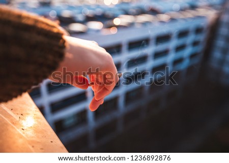 close up picture of a hand holing a cigarete. smoking, in urband background