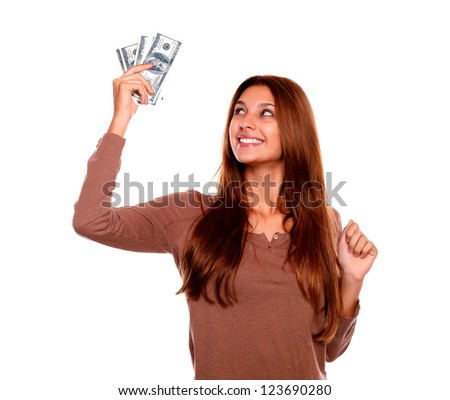 Portrait of a smiling and happy young woman holding up cash money with long brown hair on white background