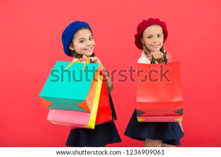 Visiting clothing mall. Discount and sale concept. Kids cute girls hold shopping bags. Shopping discount season. Special offer. Great day for shopping. Children enjoy shopping red background.