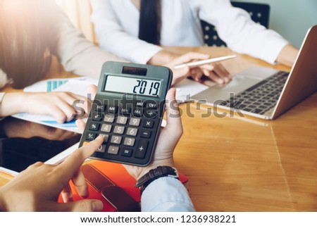 Businesswoman holding number 2019 on calculator in meeting room. Business meeting time. Royalty-Free Stock Photo #1236938221
