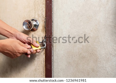 hand Unlocking padlock on the door.