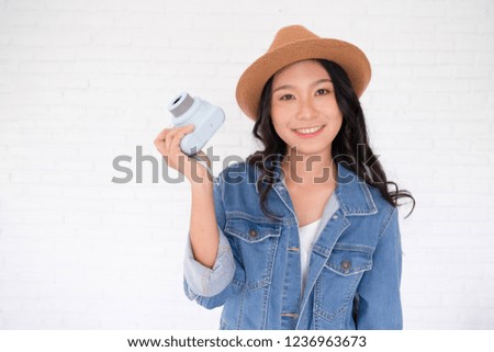 Beautiful girl wear jackets jeans and hat hold blue camera with white background