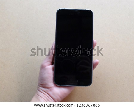 man hands holding  smart phone on brown background .Flat lay 