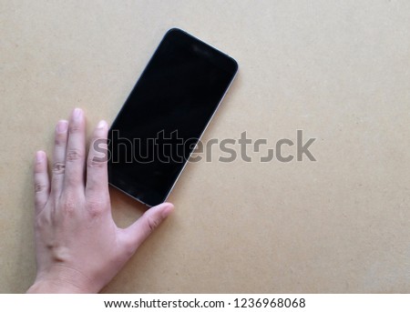 man hands holding  smart phone on brown background .Flat lay 