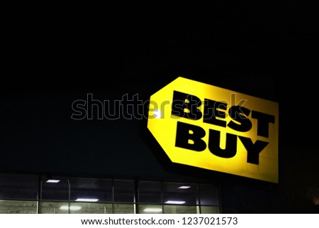 Overland Park, KS, USA, November 5, 2018: The yellow label of Best Buy, glowing at night, with ceiling of the store visible, lit with light. One of the top competitor for electronics goods in US 