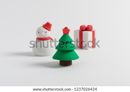 Snowman figures, gift and miniature Christmas tree with friendly pose with hat and red coat on white background. Merry Christmas