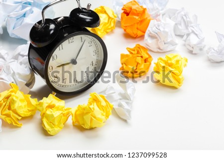 Alarm clock with crumpled paper balls.Timing and thinking idea concept.