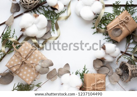 Eucalyptus leaves and cotton flowers and gift boxes on white background. Flat lay, top view. craft minimalistic presents