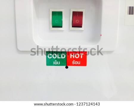 The power button at water  container with the Thai and English letters on green label that meaning of cold water and  on red label meaning of hot water