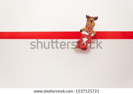 toy elk in a New Year's stocking on a white background. Animation for a happy new year greeting card. Christmas card. White background with red stripe for text.