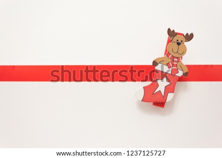 toy elk in a New Year's stocking on a white background. Animation for a happy new year greeting card. Christmas card. White background with red stripe for text.