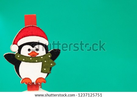 Penguin in a red hat and scarf stands on a green background. Background for new year greeting card. Template for post about Christmas