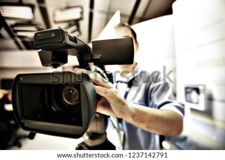 Video camera operator working with his professional equipment in television studio