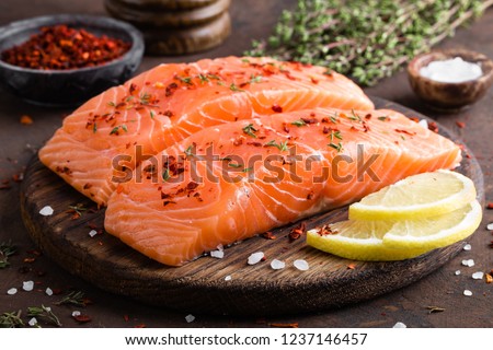 Fresh salmon fish fillet on wooden board Royalty-Free Stock Photo #1237146457