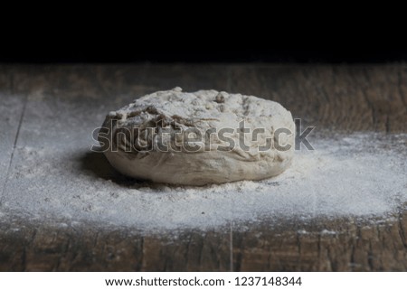 Studio photo of a ball of bread close-up and flour on a table artistic conversion