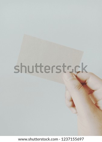 asian woman hand holding brown business card 