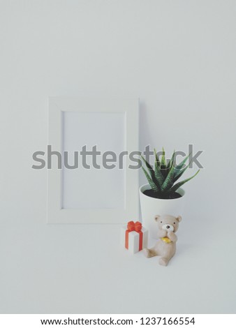 blank white photo frame with a little bear and a gift bix