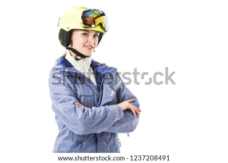 Pretty woman in blue ski jacket, goggles and helmet smiling and looking at camera isolated on white