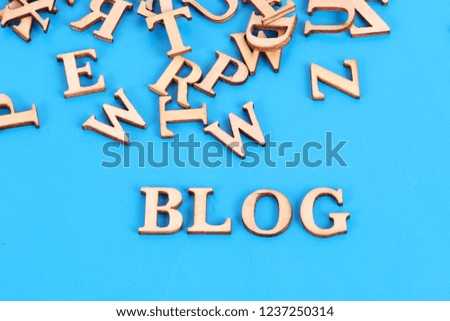 a heap of wooden letters are lying in the blue studio with the word blog in the front