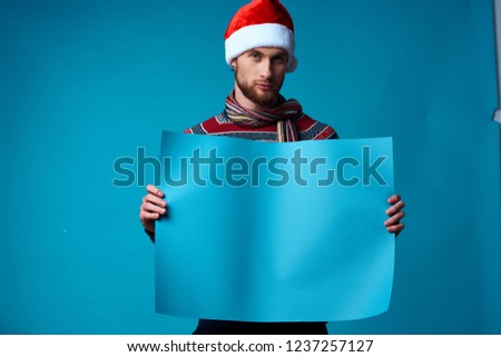 holiday hat on the head of a man with a blue sheet of paper Poster mockup                              