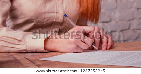 The girl signs an important document