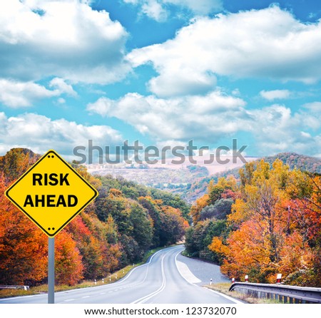"RISK AHEAD" sign against road - Business concept