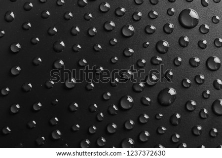 Water drops on black background, top view
