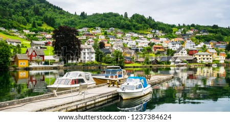 Amazing view of the pier with boats in Norheimsund near Steinsdalsfossen. Location: Norheimsund, Hardangerfjord, Norway.  Artistic picture. Beauty world.