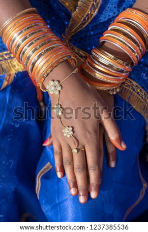 Hands of an Indian woman decorated with costume jewelry in Pushkar, India. Close up
