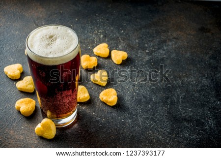 Beer and heart snack, treatment idea for Valentine's day, dark rusty background copy space