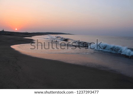 Morning Sunrise with white Sea foam Waves at the beach, Arabian Sea Coastline, Gujarat, India.
