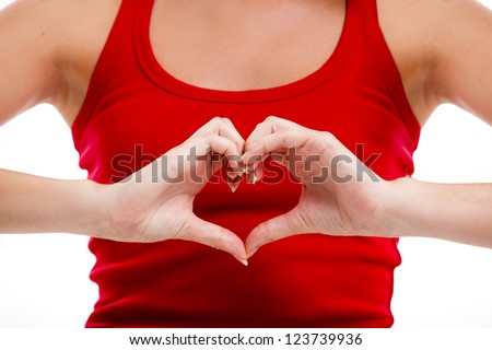 Beautiful young woman over a white background doing a heart shape with her hands Royalty-Free Stock Photo #123739936