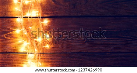 Image of wooden surface with burning garland on side.