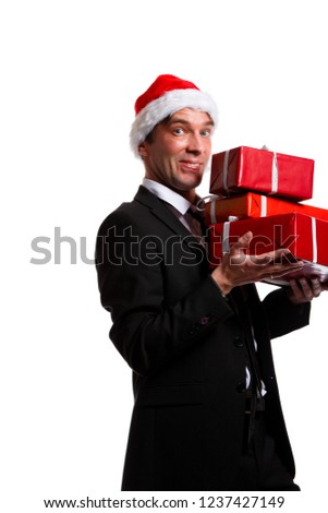 Picture of cheerful brunet in business suit, santa hat with gifts in boxes