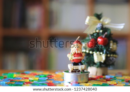 Candle Santa Claus on table in library A small Christmas tree is the background selective focus and shallow depth of field