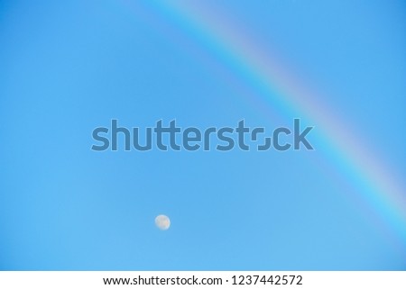 blue sky a moon and rainbow.