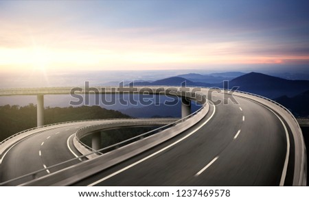 Highway overpass motion blur with nature mountain background during sunrise Royalty-Free Stock Photo #1237469578