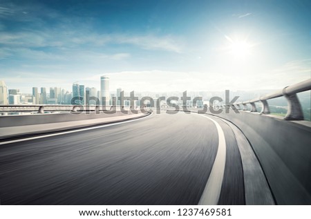 Highway overpass motion blur effect with modern city background Royalty-Free Stock Photo #1237469581