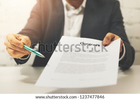 partnership - businessman giving business contract to sign