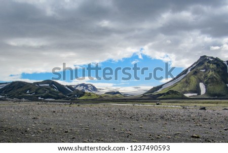 Stunning view on green mountains covered with moss and snow and Myrdalsjokull glacier in Maelifellsandur volcanic desert, on the Laugavegur Trail between Emstrur-Botnar and Alftavatn, central Iceland