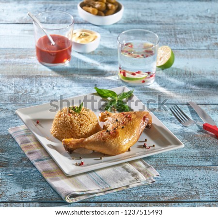 Chicken and rise eating on the plate and water glass background with blue wooden table.
