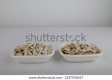 in a white container, full and empty sunflower seeds