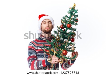 Man with New Year's Man with a Christmas tree decorated with toys                    