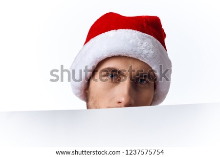 A man covers his face with a white mockup in a New Year's hat                     